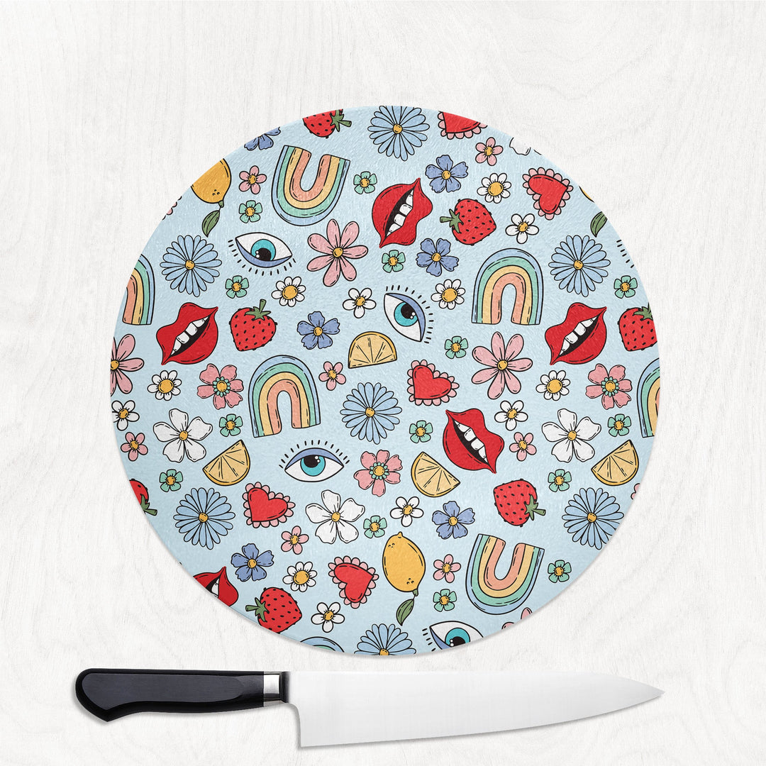 Colourful round gpatterned cutting board with a knife on a white background