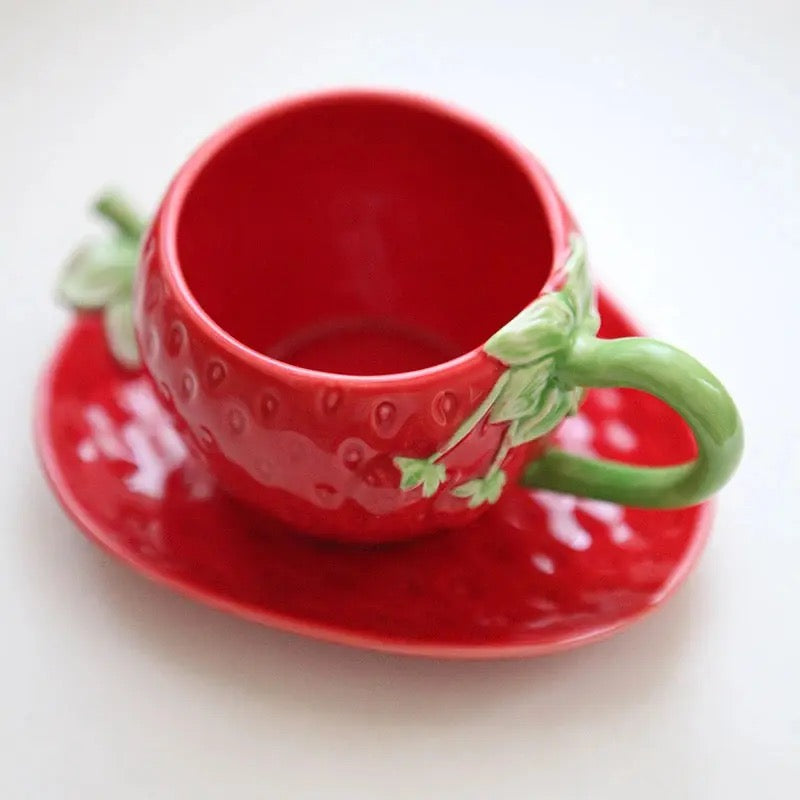 Set aus Tassen und Untertassen in roter Erdbeerform