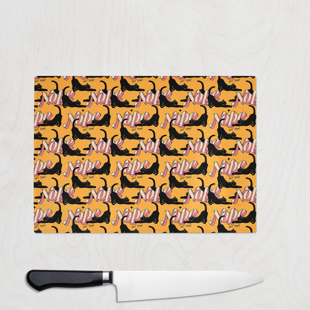 The Yililo Nope Funny Cat Glass Chopping Board features black cats stretching near bold “NOPE” lettering on orange. This durable, heat-resistant board comes with a black-handled knife, perfect for any playful kitchen.