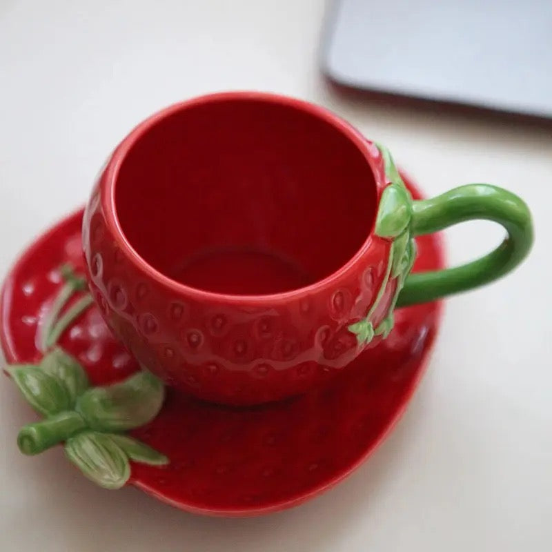 Set aus Tassen und Untertassen in roter Erdbeerform