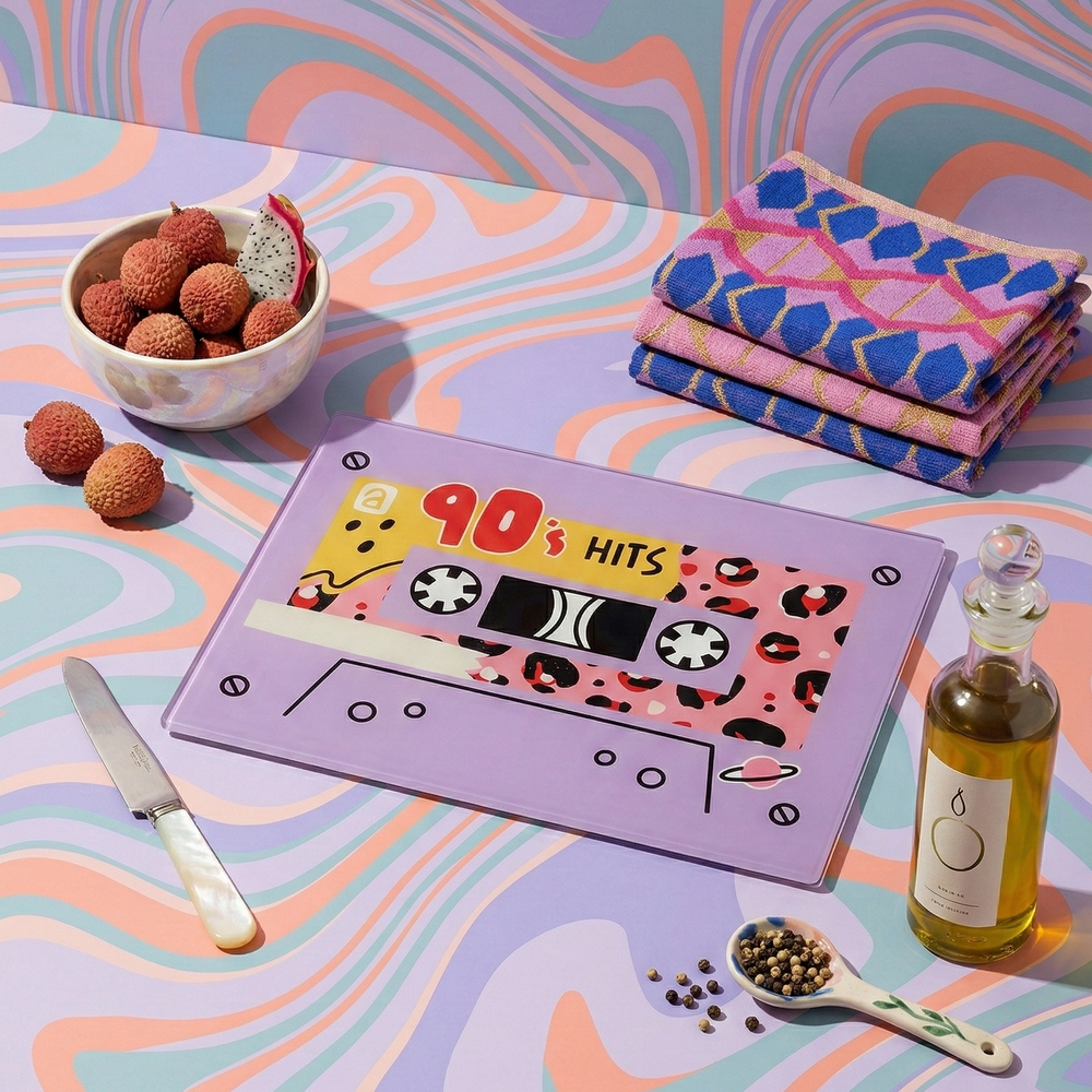 lilac chopping board saying 90s hits against a 90s swirly backdrop with colourful props