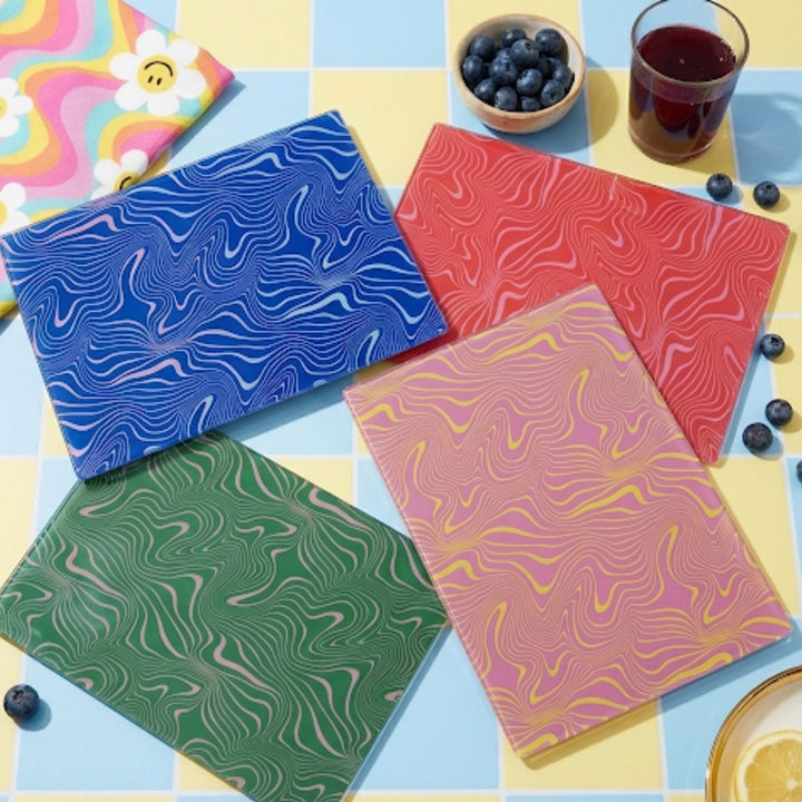 Four colorful notebooks with marbled patterns on a multicolored surface.