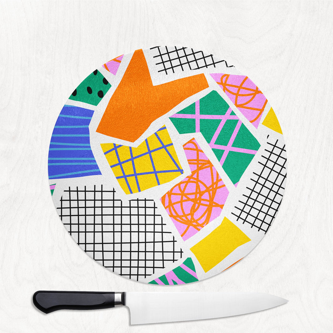 Colorful geometric-patterned cutting board with a knife on a white background