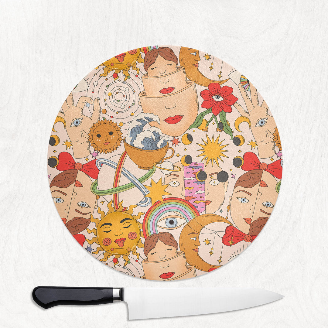 Round cutting board with colorful face design and a knife on a white background