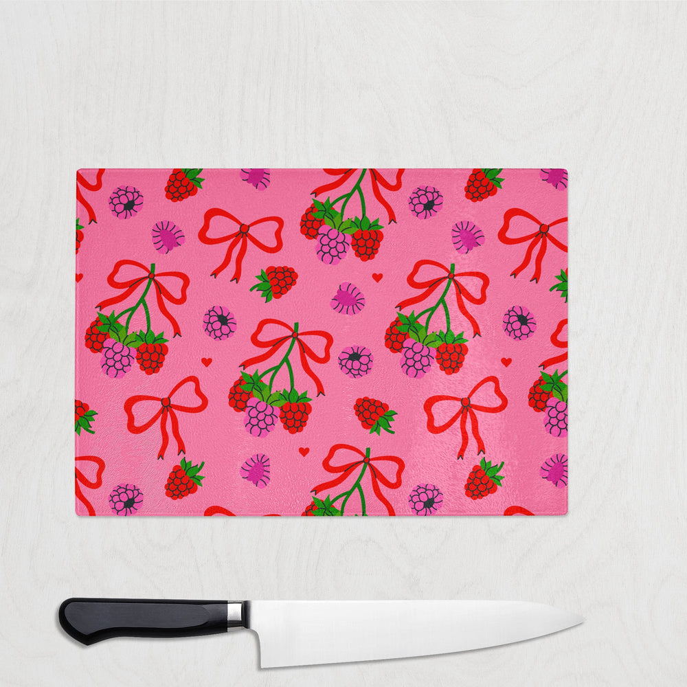 Bright pink chopping board with red bows and raspberry berry clusters – fun and fruity kitchen accessory