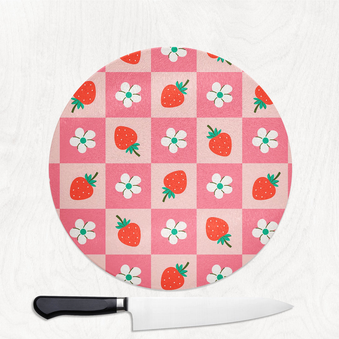 Round cutting board with strawberry and flower pattern on a white background