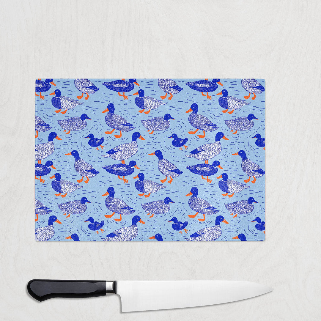 Blue Ducks glass chopping board with hand-illustrated mallards on blue water