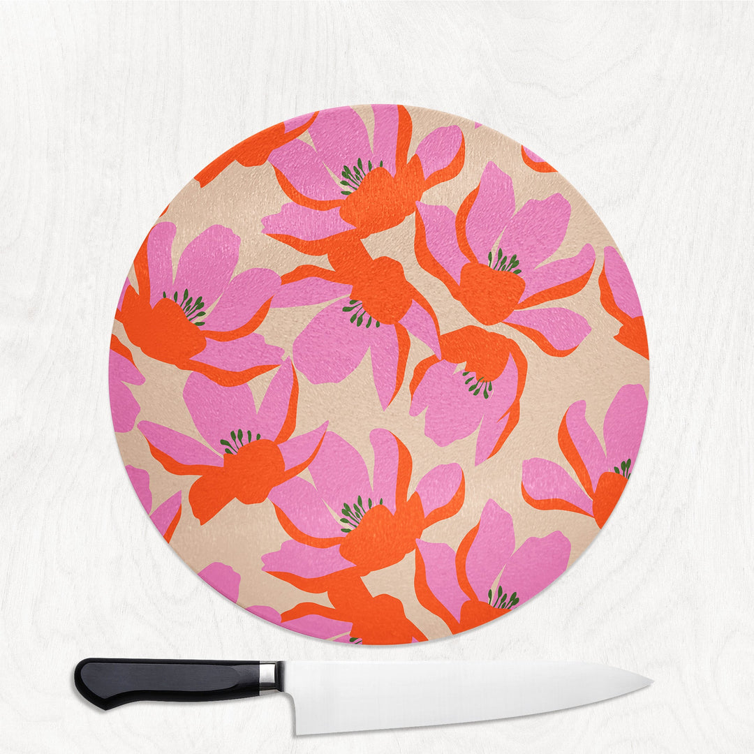 Round cutting board with floral pattern and a knife on a white background