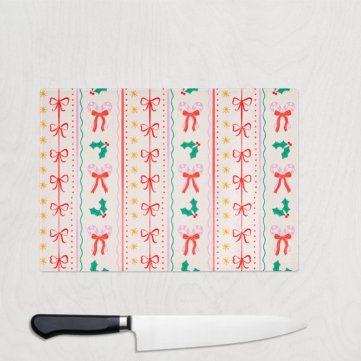 Chopping board with festive bow pattern and a knife on a white background