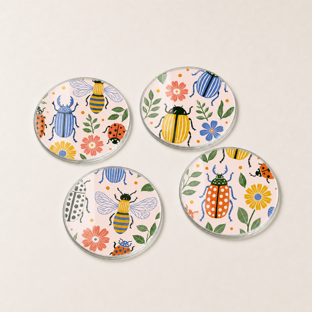 Four round glass ceramic coasters with beetle and floral designs on a beige background