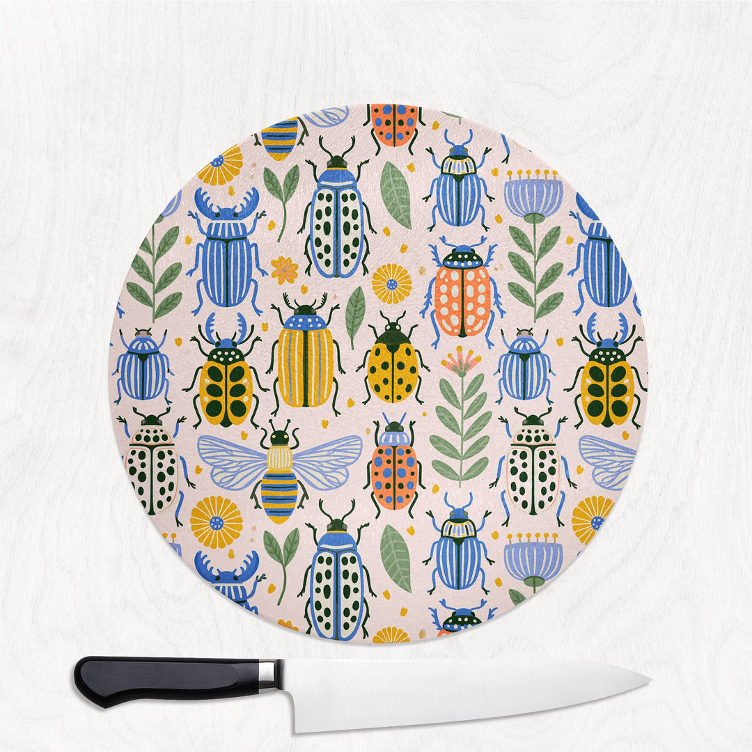 Bugs in Colour round glass chopping board with hand-painted beetles, bees and ladybirds