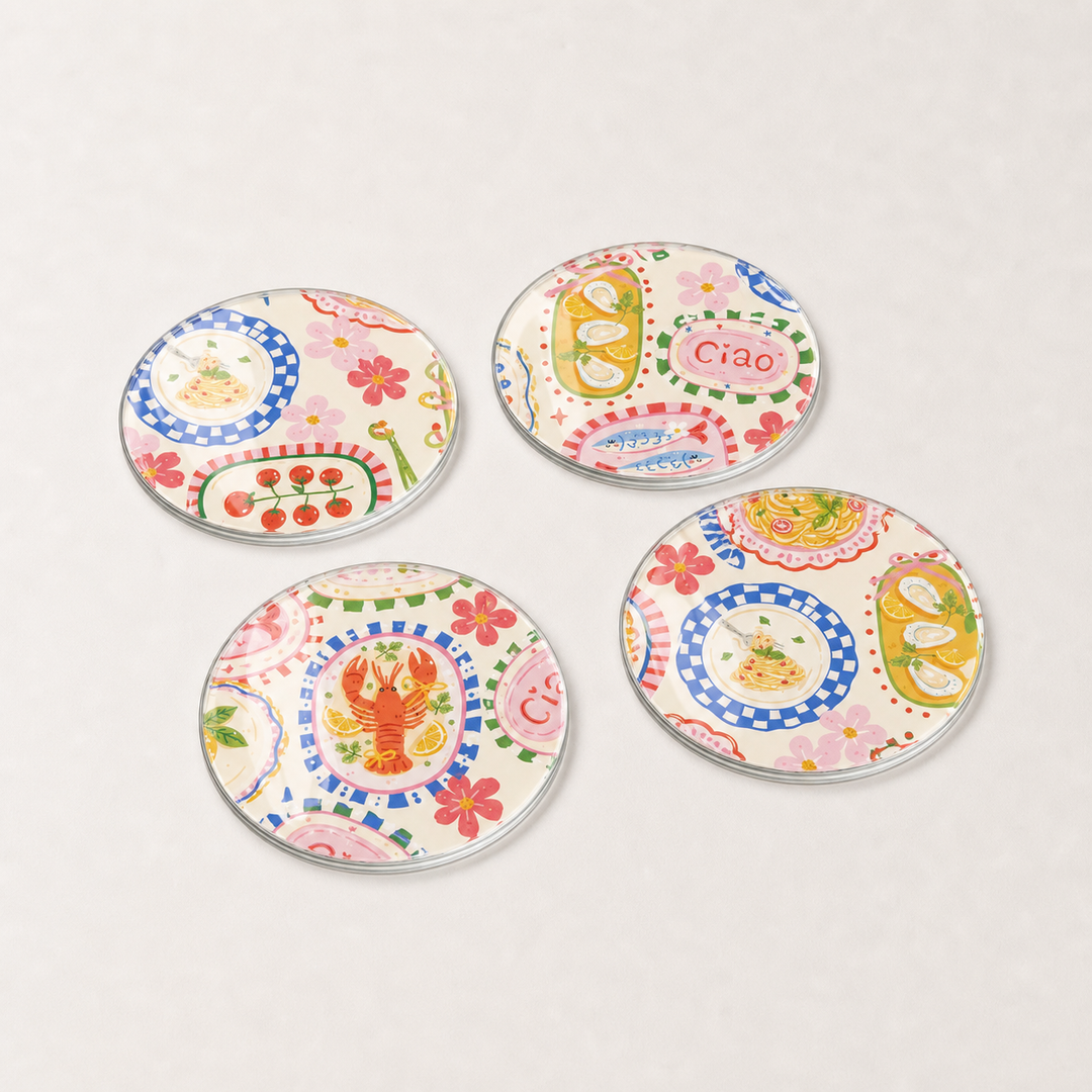 Four colourful glass coasters with various designs on a light gray background