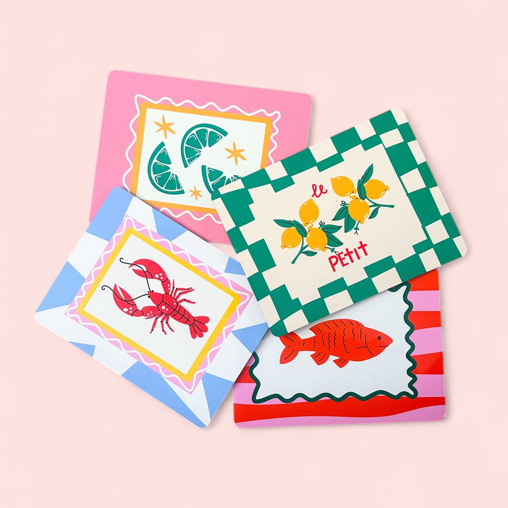 Brighten your table with Yililos Citrus And The Sea Placemats – Set of 4, featuring lemon on green checks, lime on pink, a red lobster on yellow, and a red fish on stripes for a fun coastal vibe.