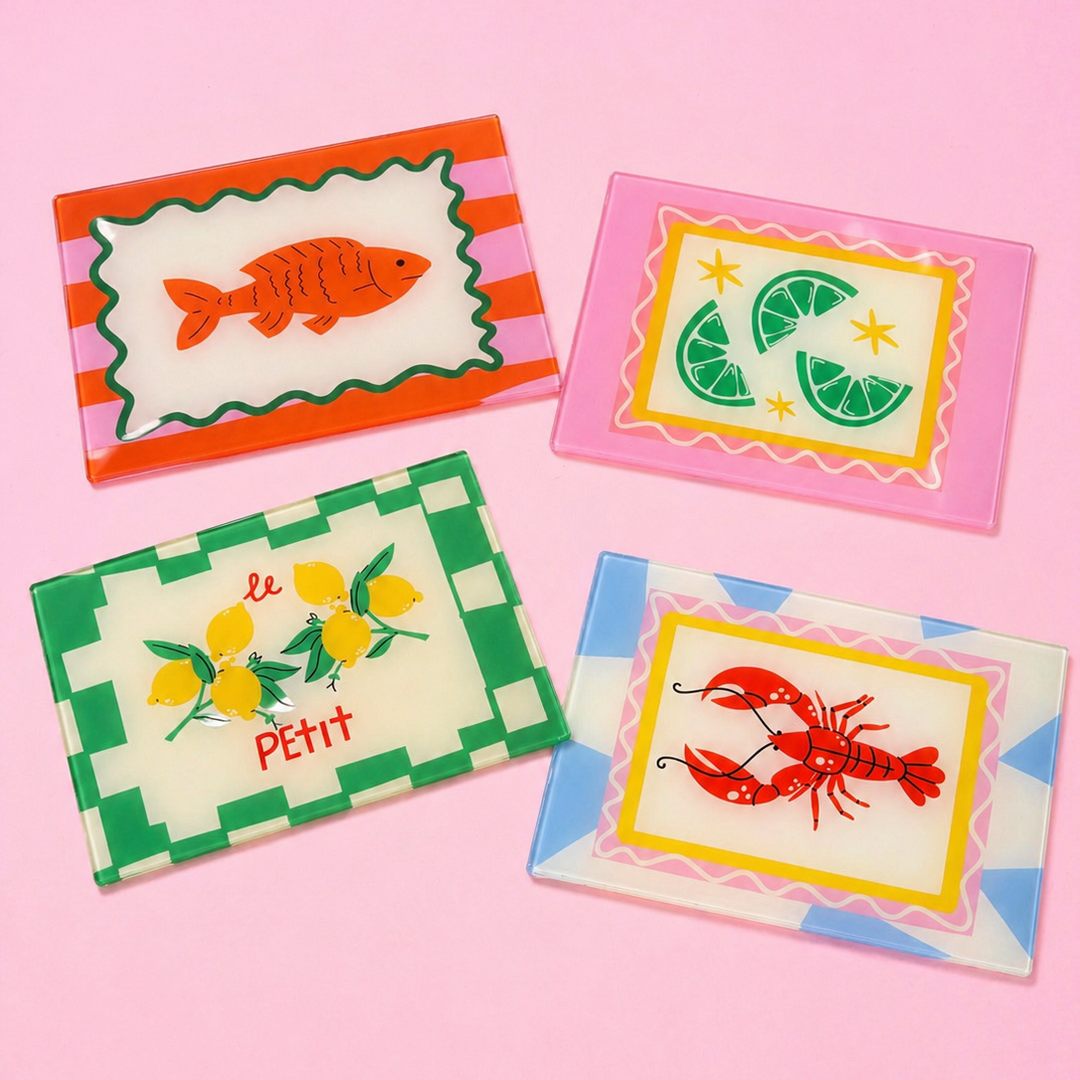 Four colourful glass placemats with animal illustrations on a pink background