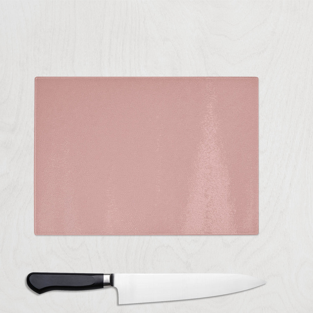 Pink cutting board with a knife on a light gray background
