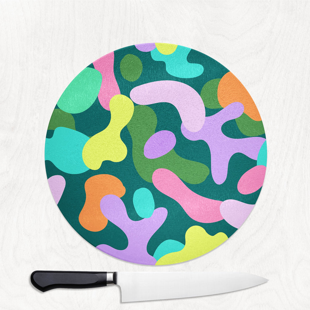 Colorful abstract patterned cutting board with a knife on a white background