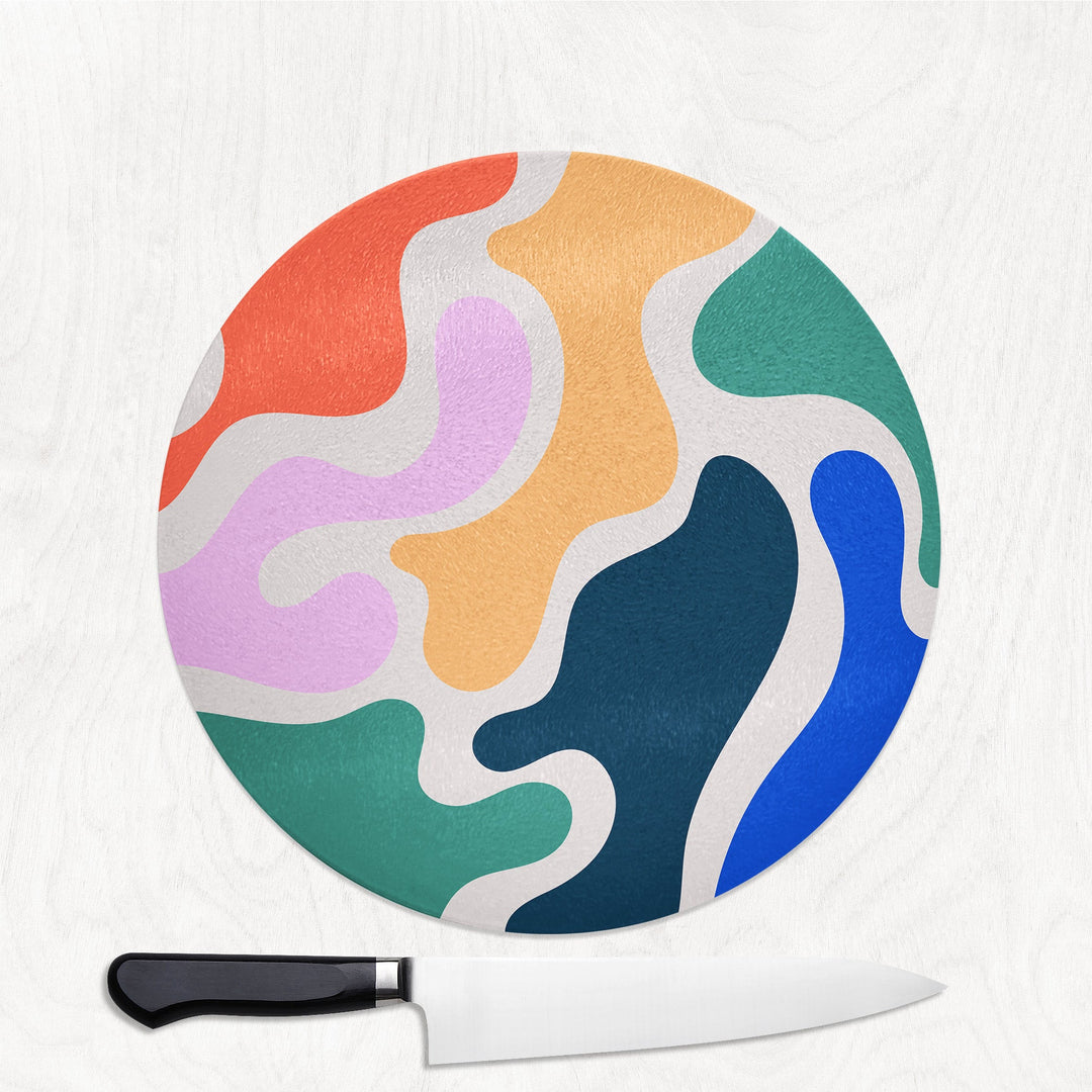 Colorful circular cutting board with a knife on a white background