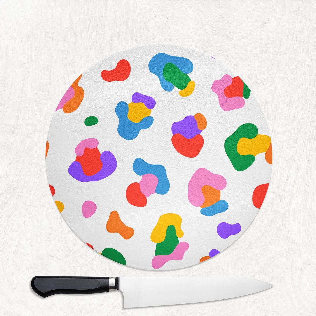 Colorful abstract patterned cutting board with a knife on a white background