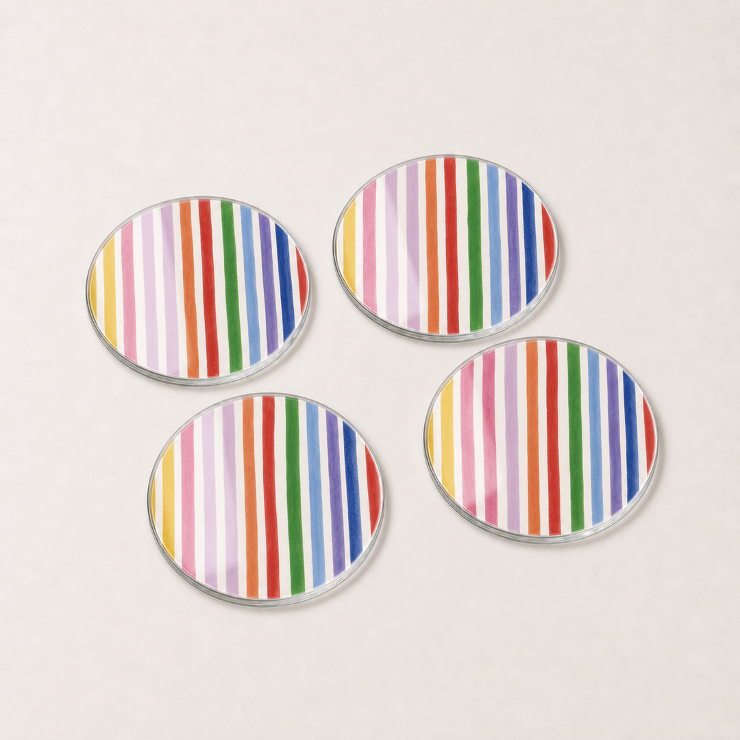 Four round glass coasters with multicolored striped pattern on a light gray background