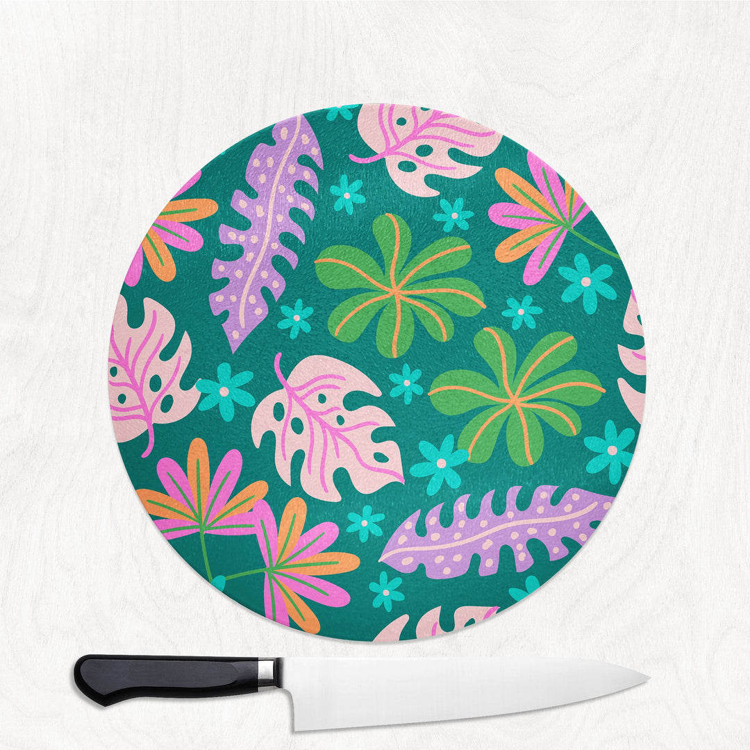 Round cutting board with colorful leaf pattern on a white background