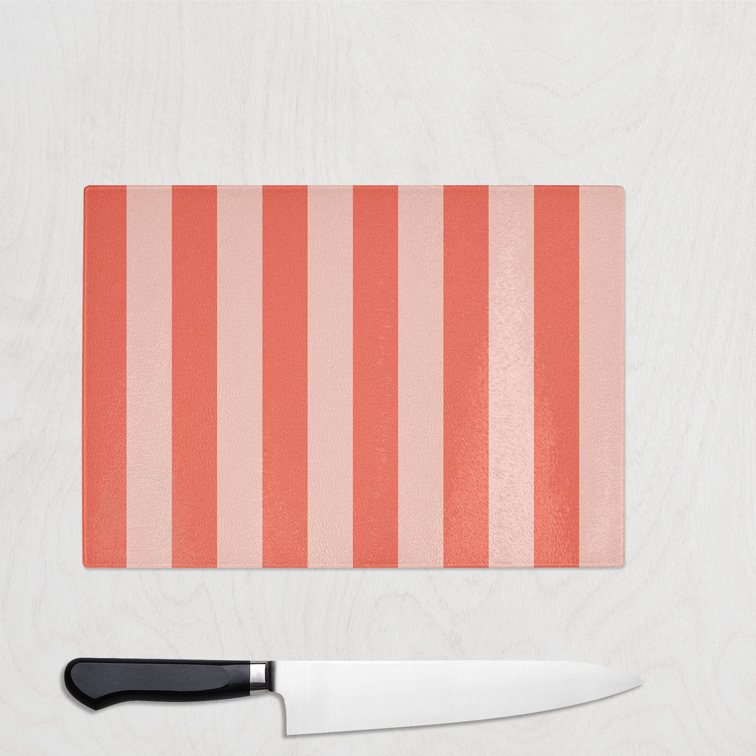 Coral Striped cutting board with a knife on a light gray background