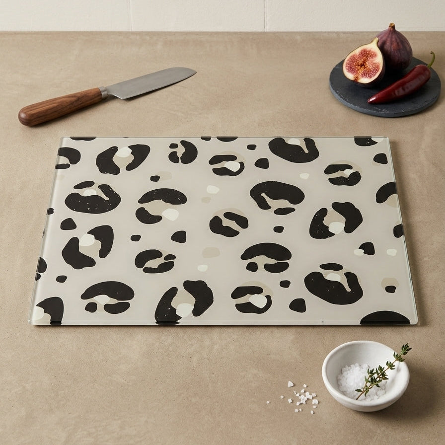 Leopard print cutting board on a beige surface with a knife and figs.