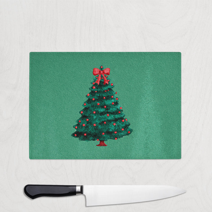 Green Chopping Board with a Christmas tree design on a white surface with a knife.