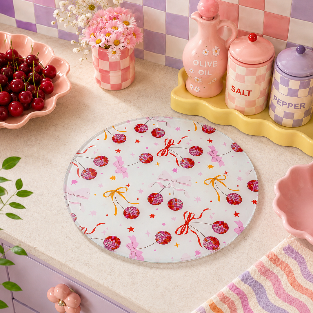 Round disco cherry ball cutting board with decorative pattern on a kitchen counter
