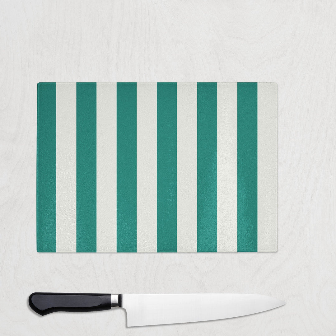 Striped Green and white cutting board with a knife on a white background