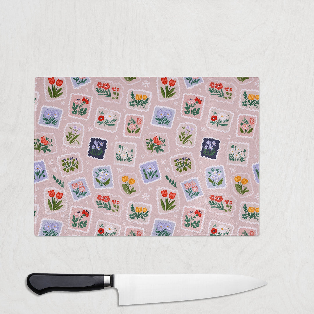 Chopping board with floral pattern and a knife on a light gray background