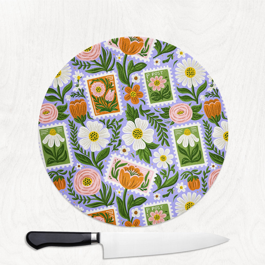 Floral Stamps round glass chopping board with postage-stamp florals, daisies and blooms