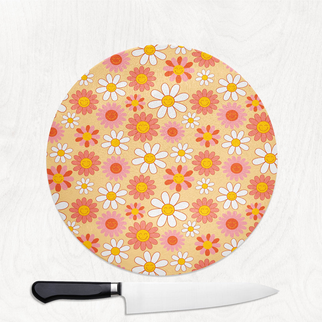 Round cutting board with floral pattern and a knife on a white background