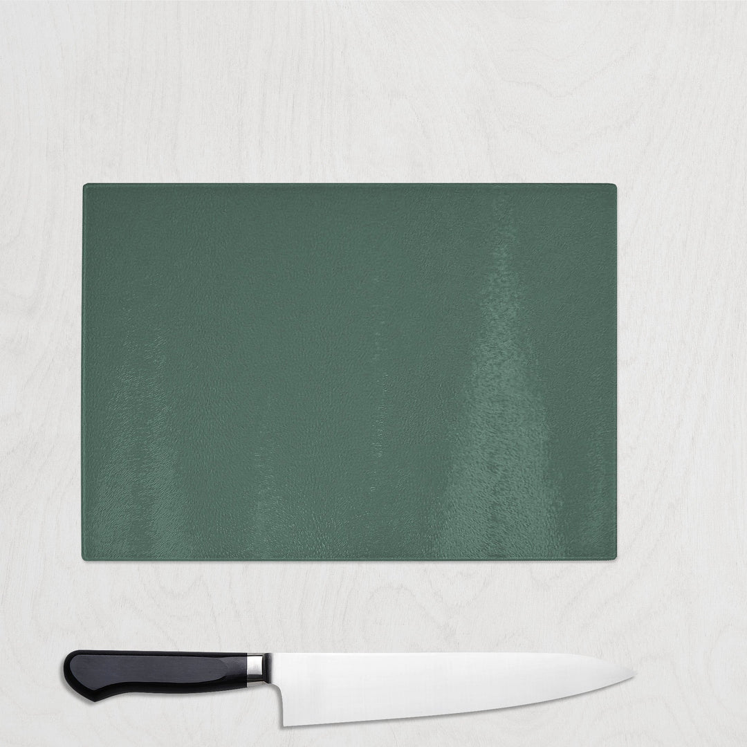 Green cutting board with a knife on a light gray background