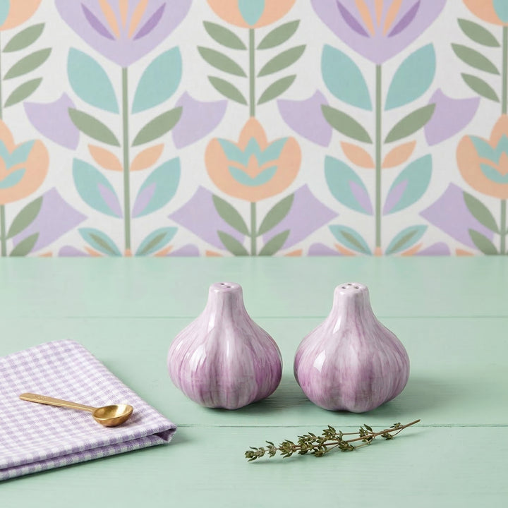 Two purple ceramic bottles on a green surface with a floral patterned wall in the background.