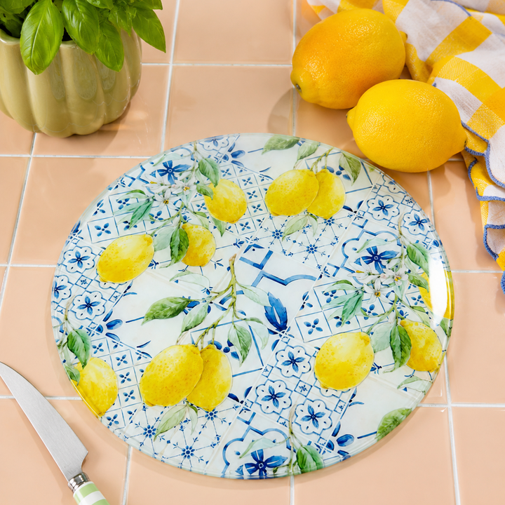 Decorative worktop saver with lemon design on a tiled surface with lemons and a knife.