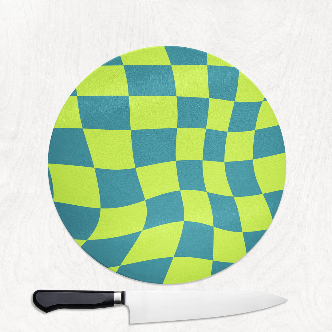 Round green and blue checkered cutting board with a knife on a white background