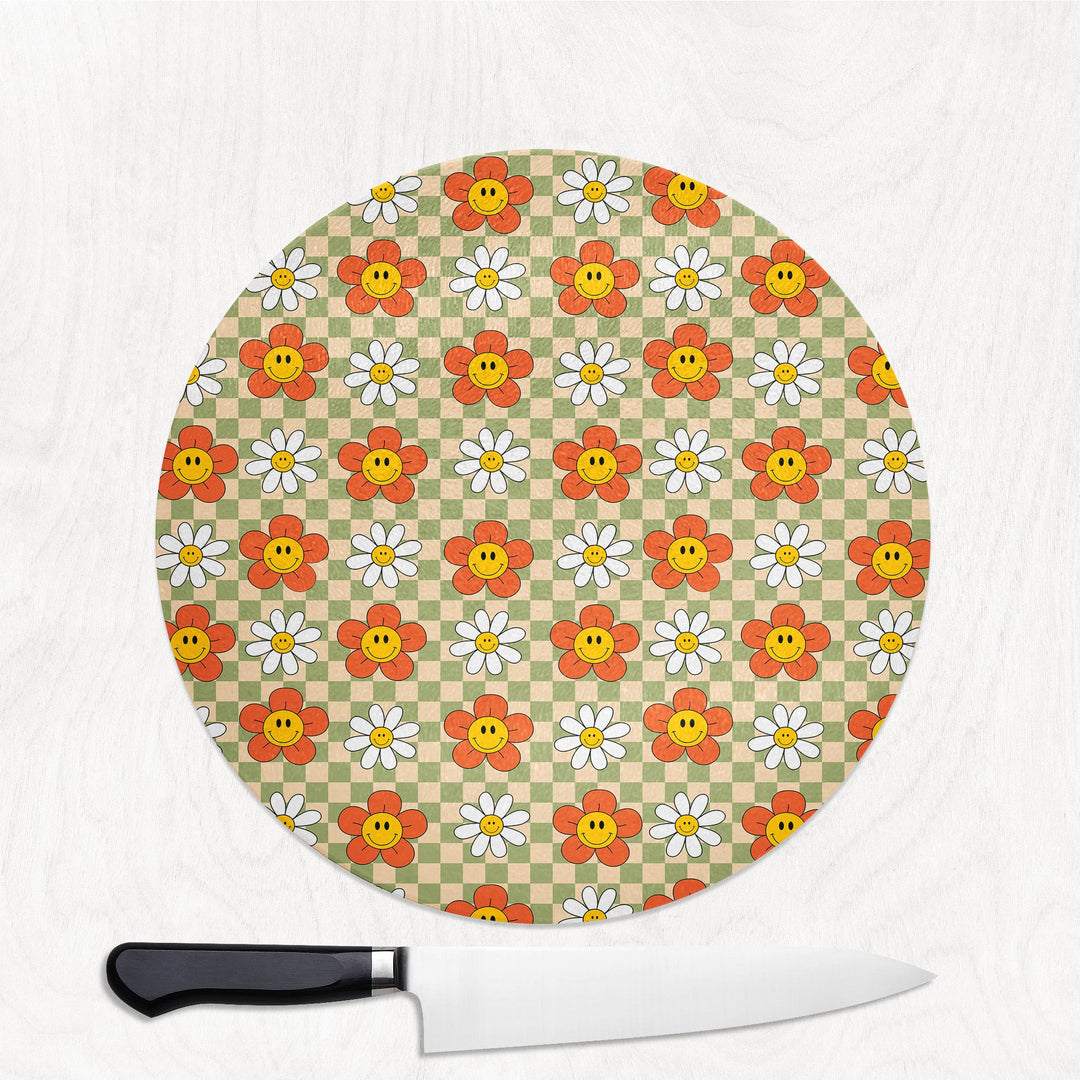 Round cutting board with floral pattern and a knife on a white background