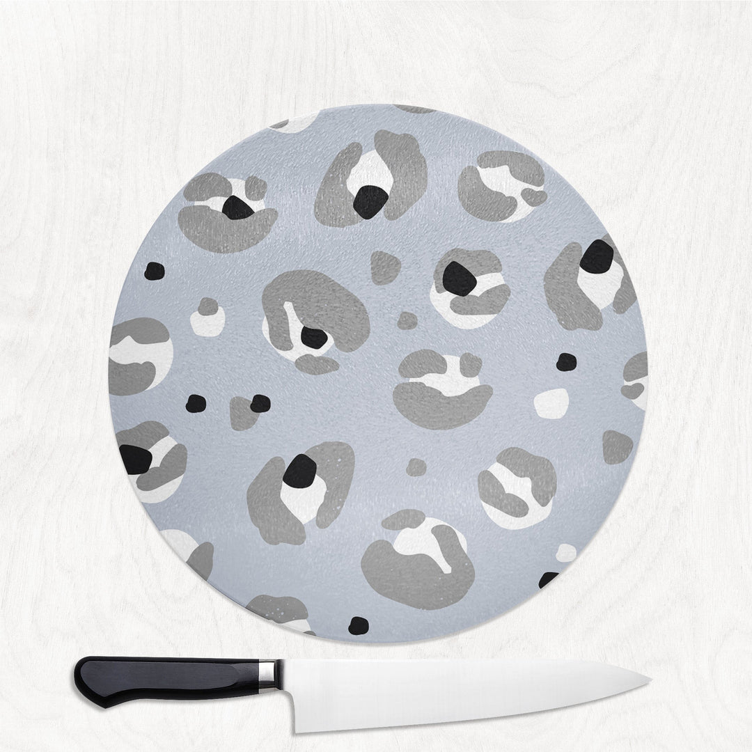 Round cutting board with gray leopard print pattern on a white background