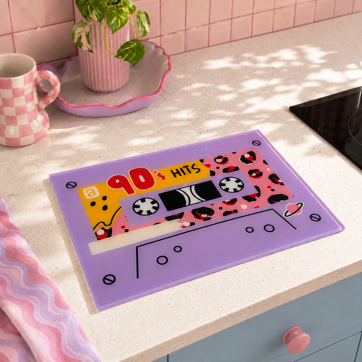 Retro 90s cassette tape design, placed on a light beige kitchen countertop next to a pink mug and a plant.