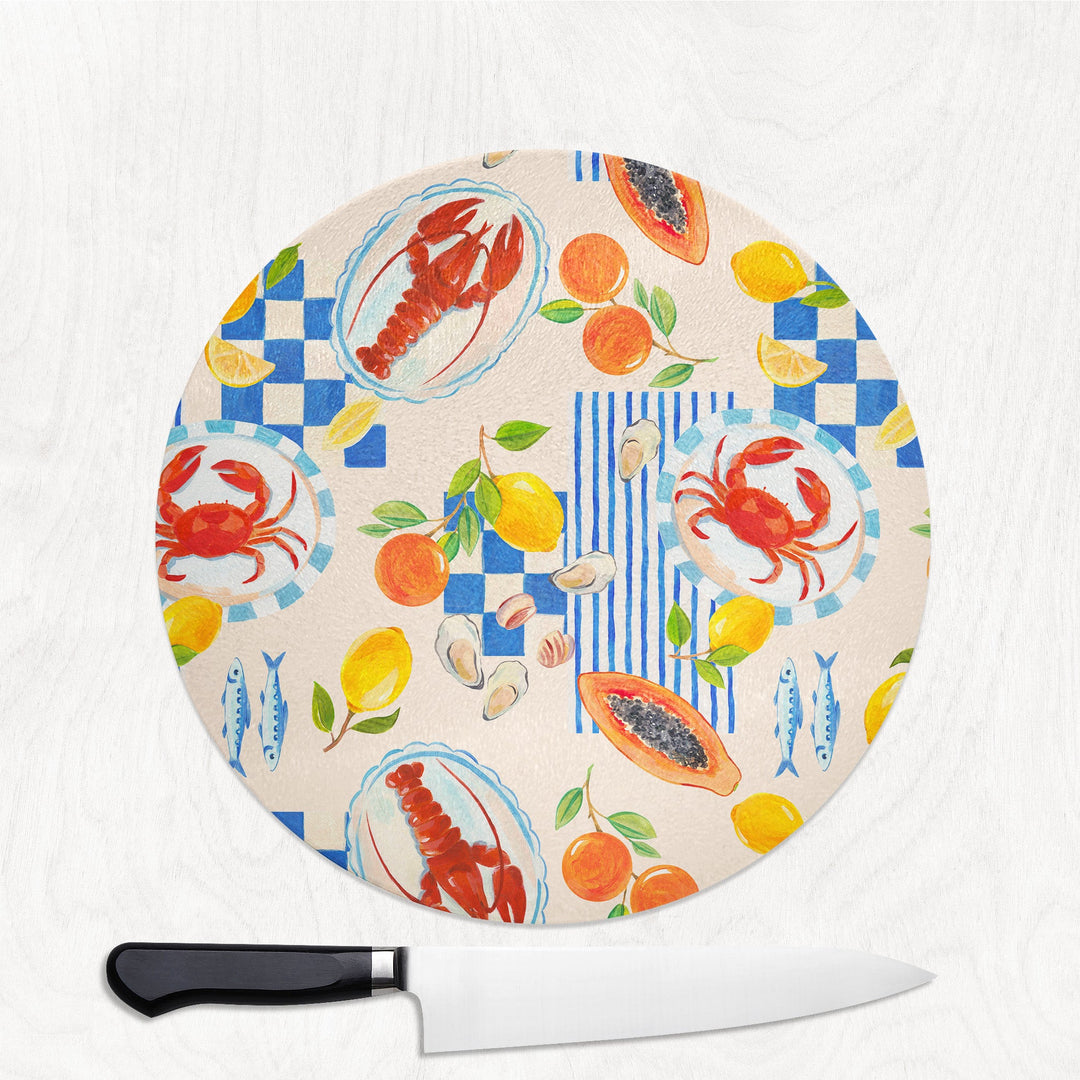 Round cutting board with colorful seafood and fruit pattern on a white background