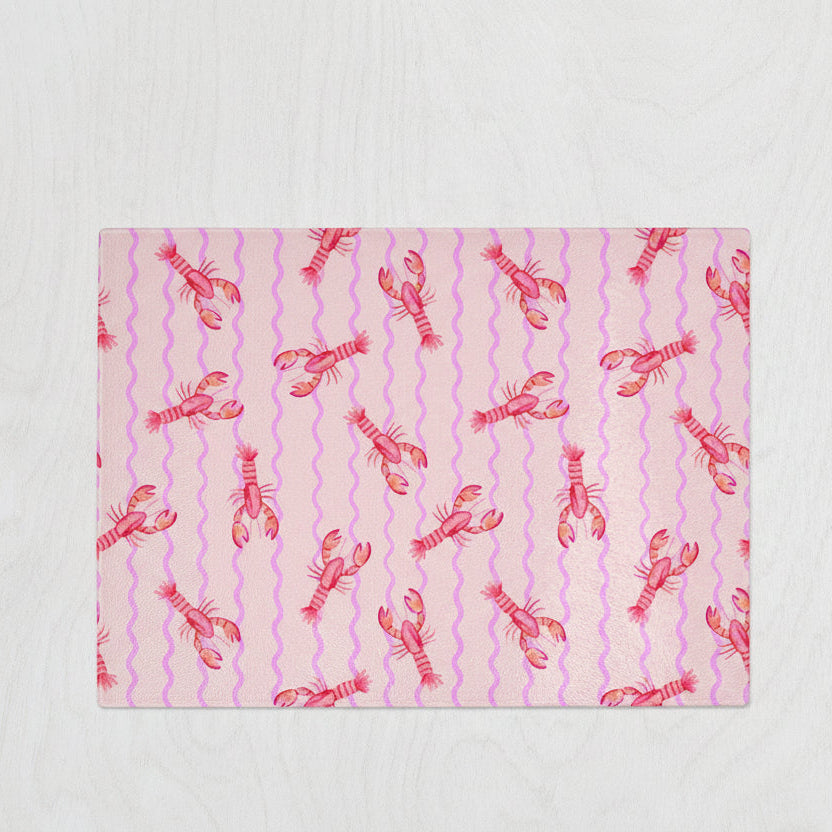 Pink glass chopping board with coral lobsters and wavy lilac lines – fun seafood-themed kitchen decor