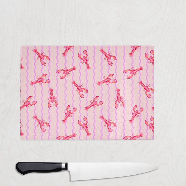 Pink glass chopping board with coral lobsters and wavy lilac lines – fun seafood-themed kitchen decor