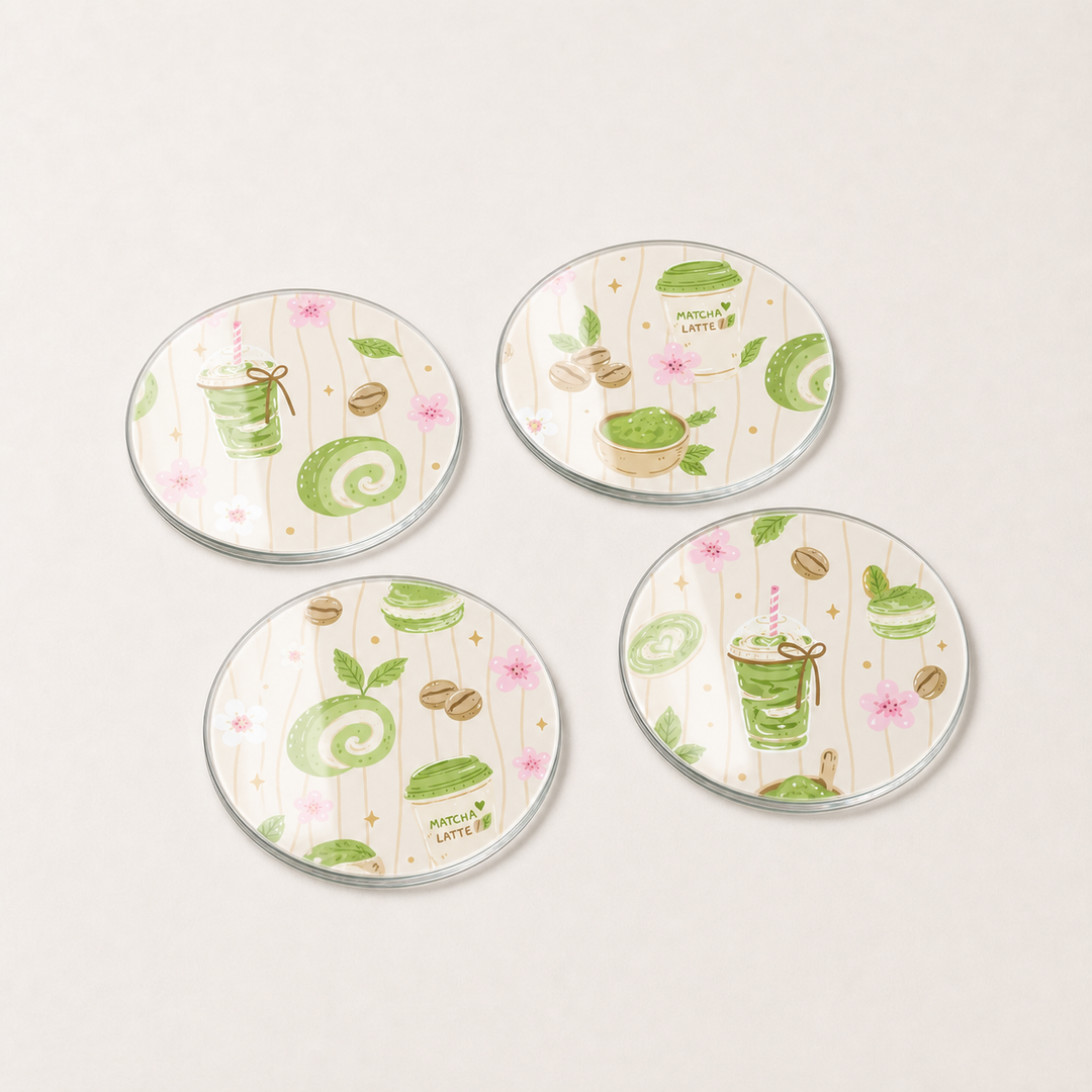 Four round coasters with matcha latte-themed designs on a white background