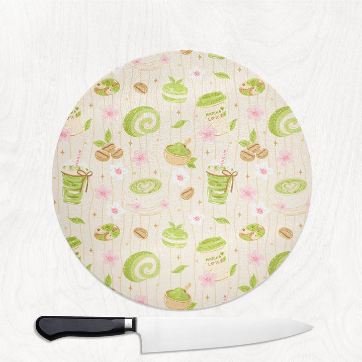 Matcha and Cake round glass chopping board with matcha lattes, swiss rolls and cherry blossom
