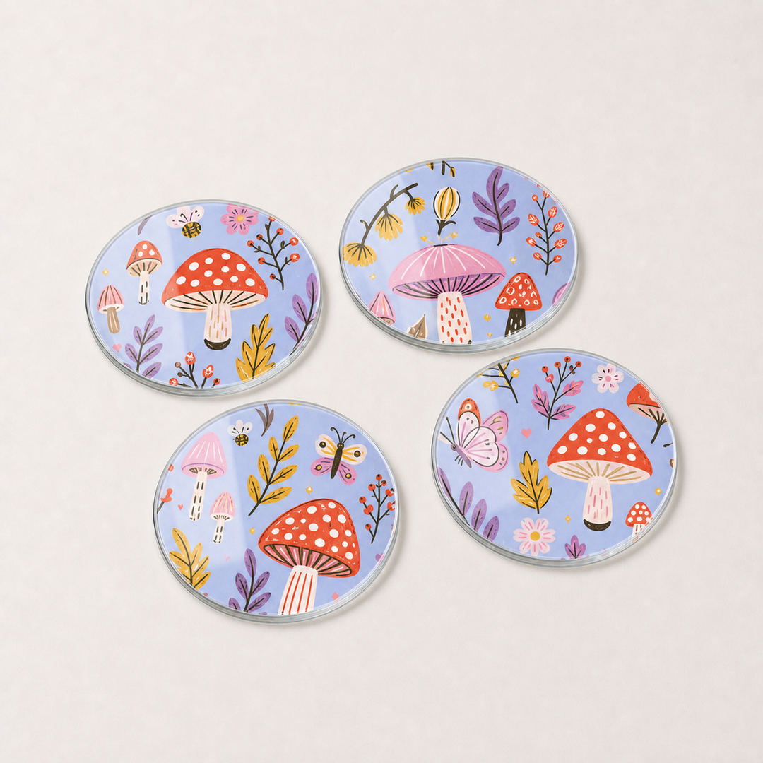 Set of four colorful glass coasters with mushroom and floral designs on a light gray background