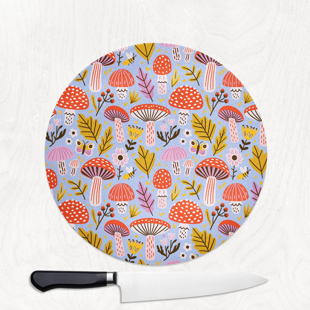 Mushroom Magic round glass chopping board with toadstools, leaves, bees and butterflies