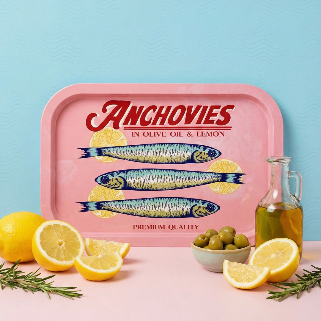 Pink tray with anchovies design, lemons, and olive oil on a light blue background