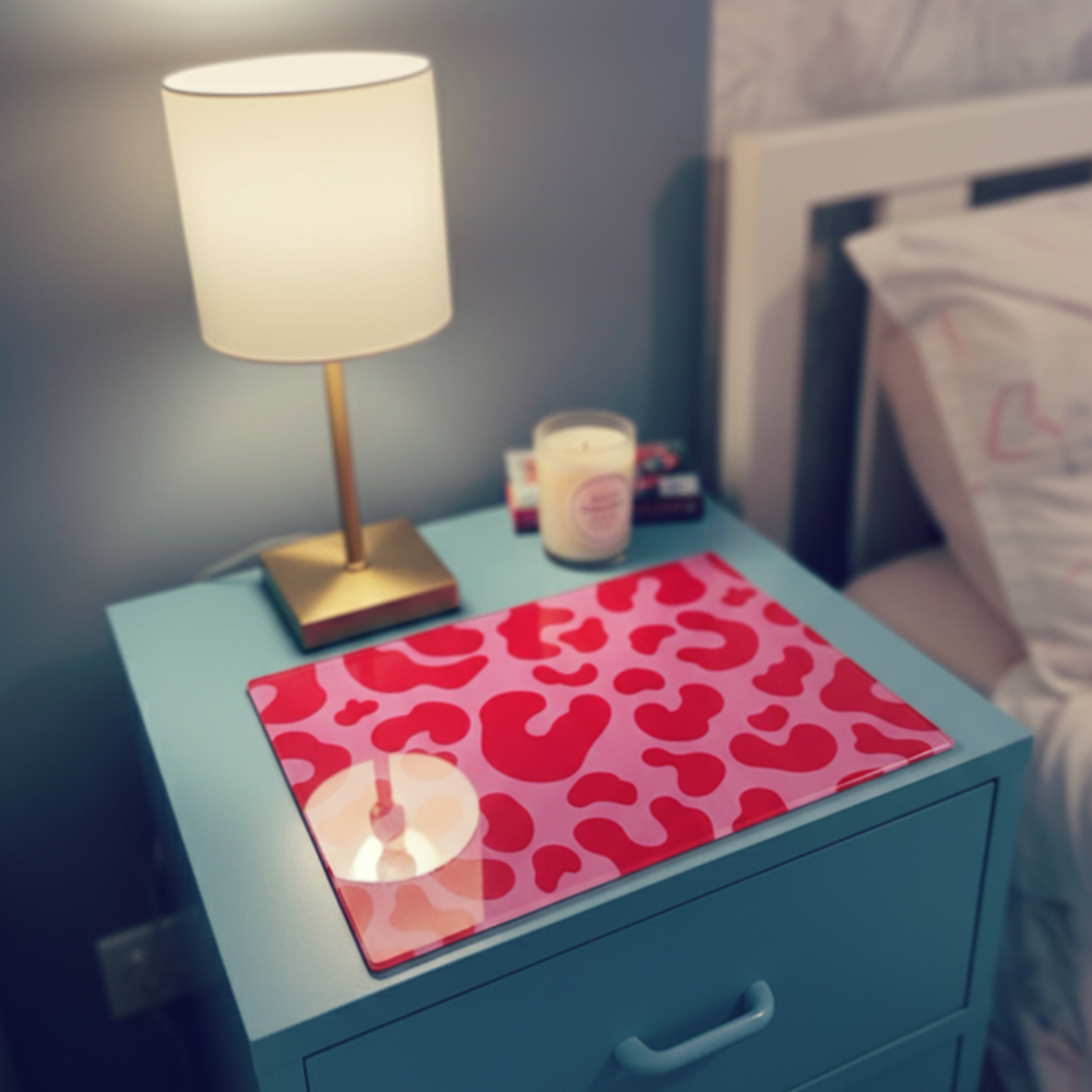 Blue nightstand with a pink leopard print placemat, white lamp, and candles.