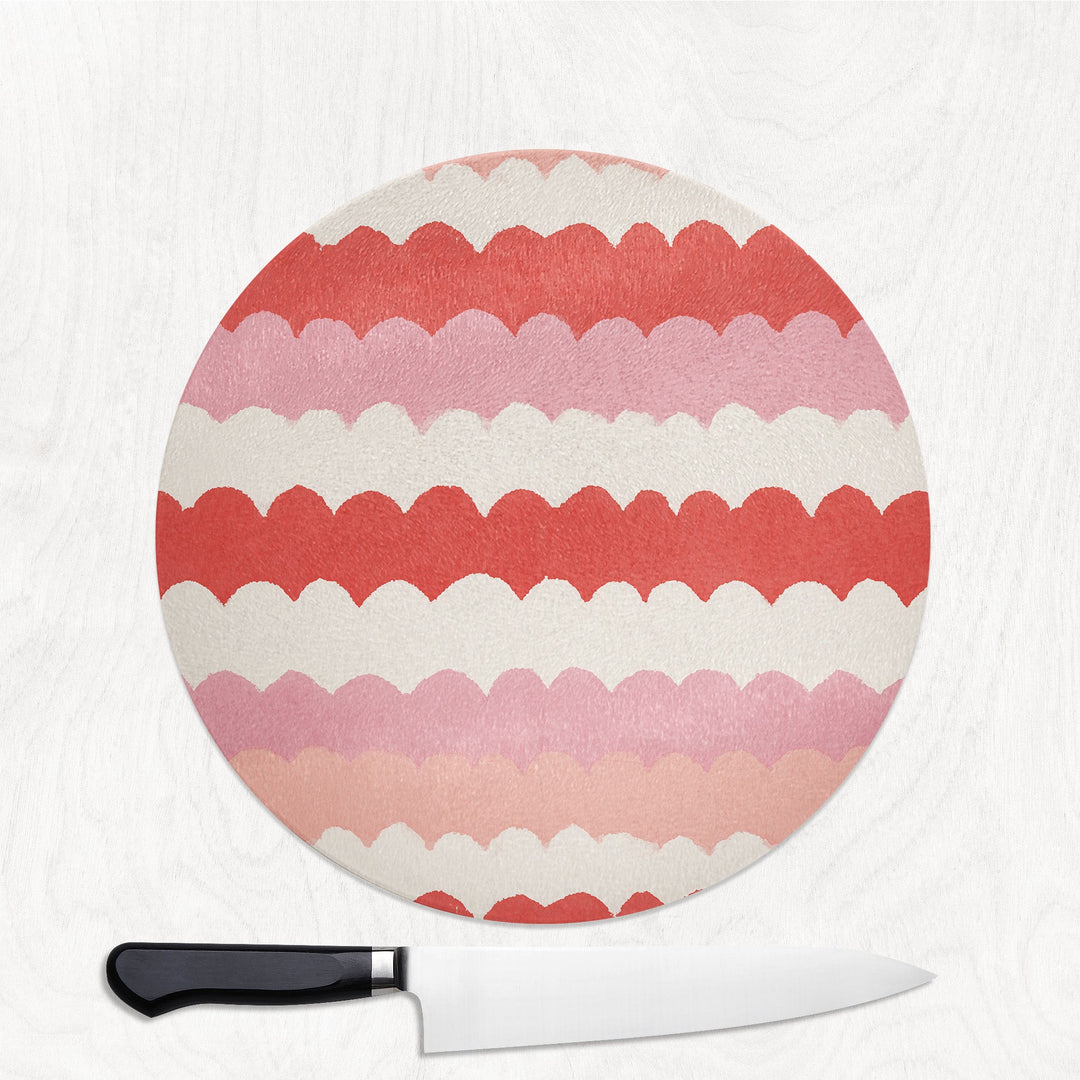 Pink Scallop Wave round glass chopping board with soft scalloped waves of pink and coral