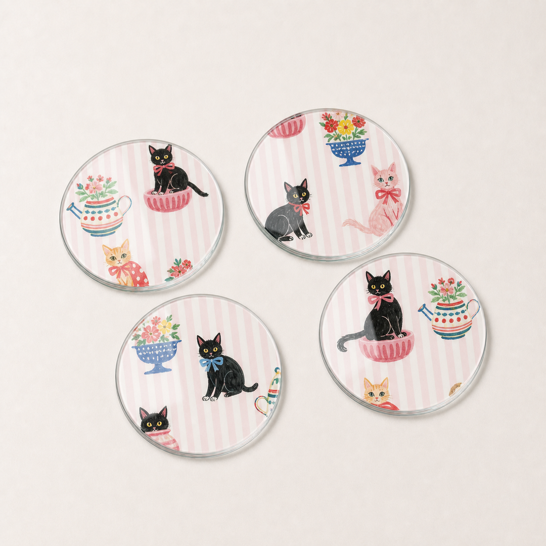 Set of four glass coasters with cat illustrations on a white background